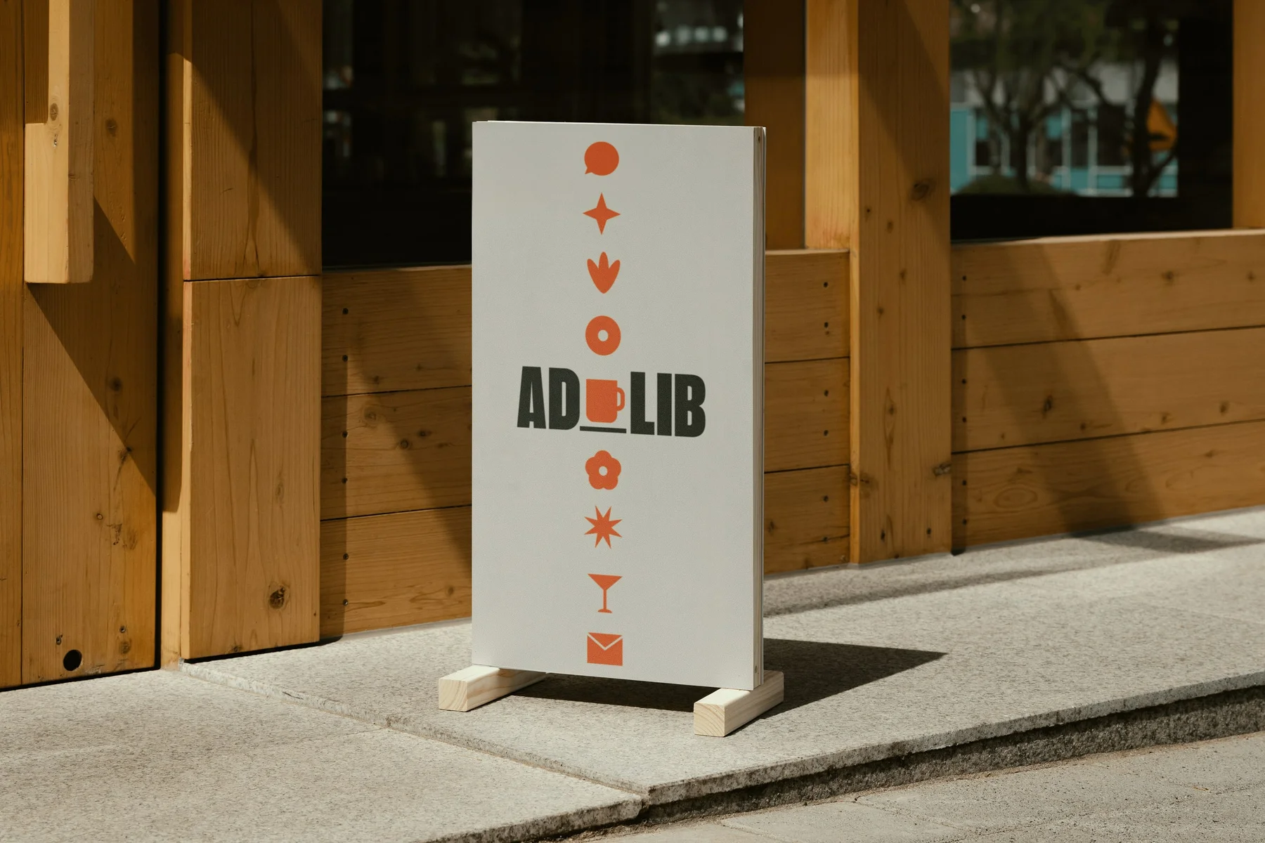 Freestanding cafe sign with a vertical column of orange symbols.
