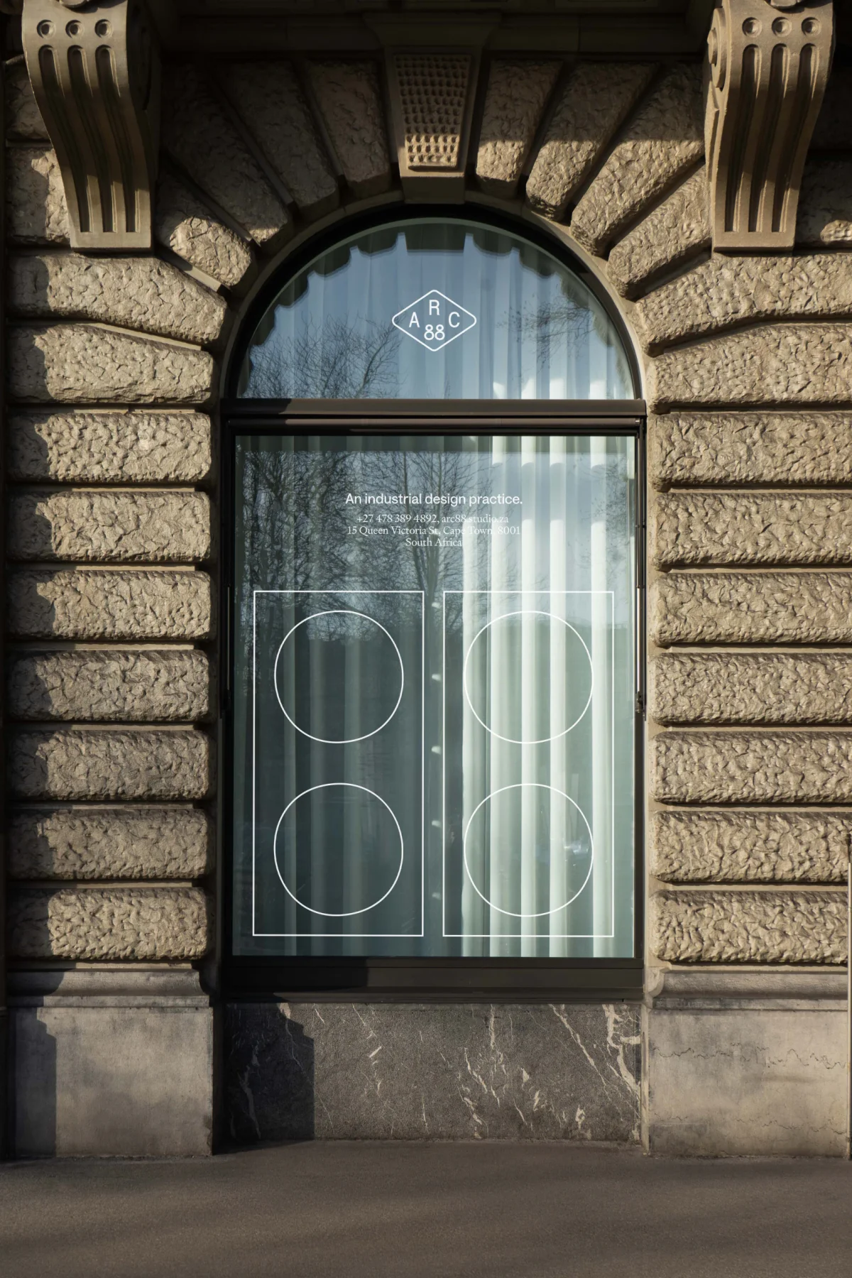 Outlined Arc 88 symbols applied to an arched storefront window.