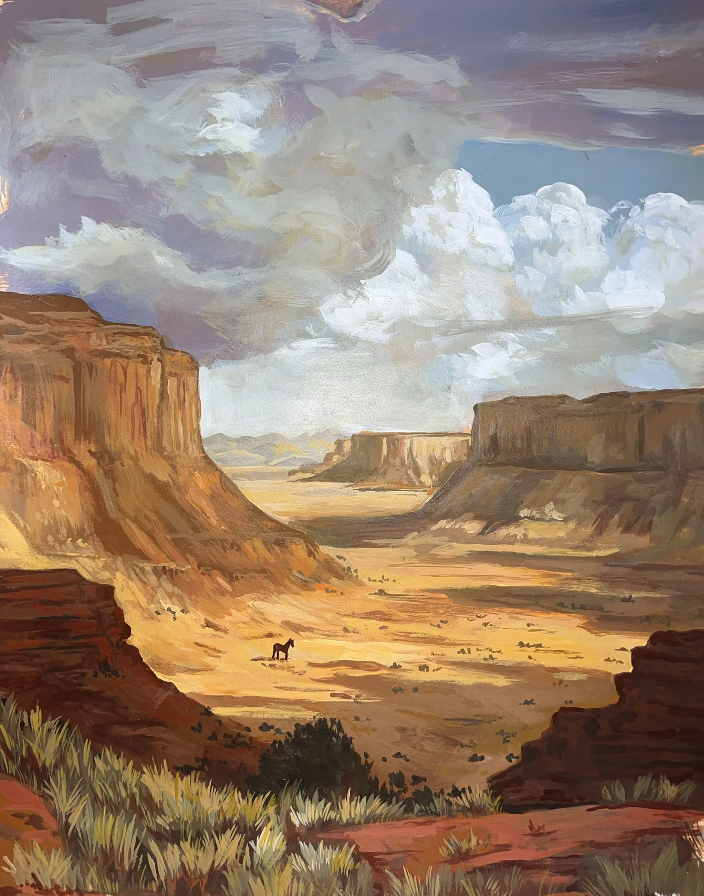 Painted desert canyon landscape with a small rider.