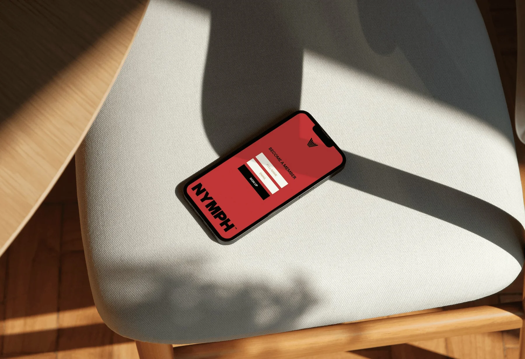 Red Nymph mobile website on a phone resting on a chair.