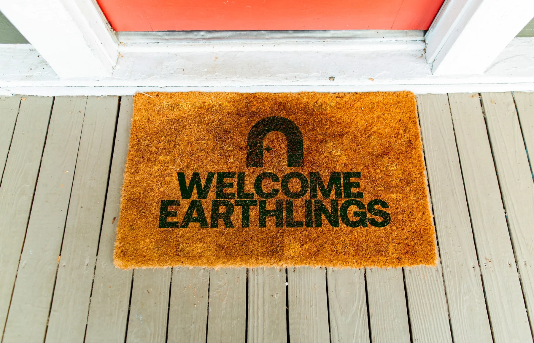 Green Nomad doormat reading Welcome Earthlings.