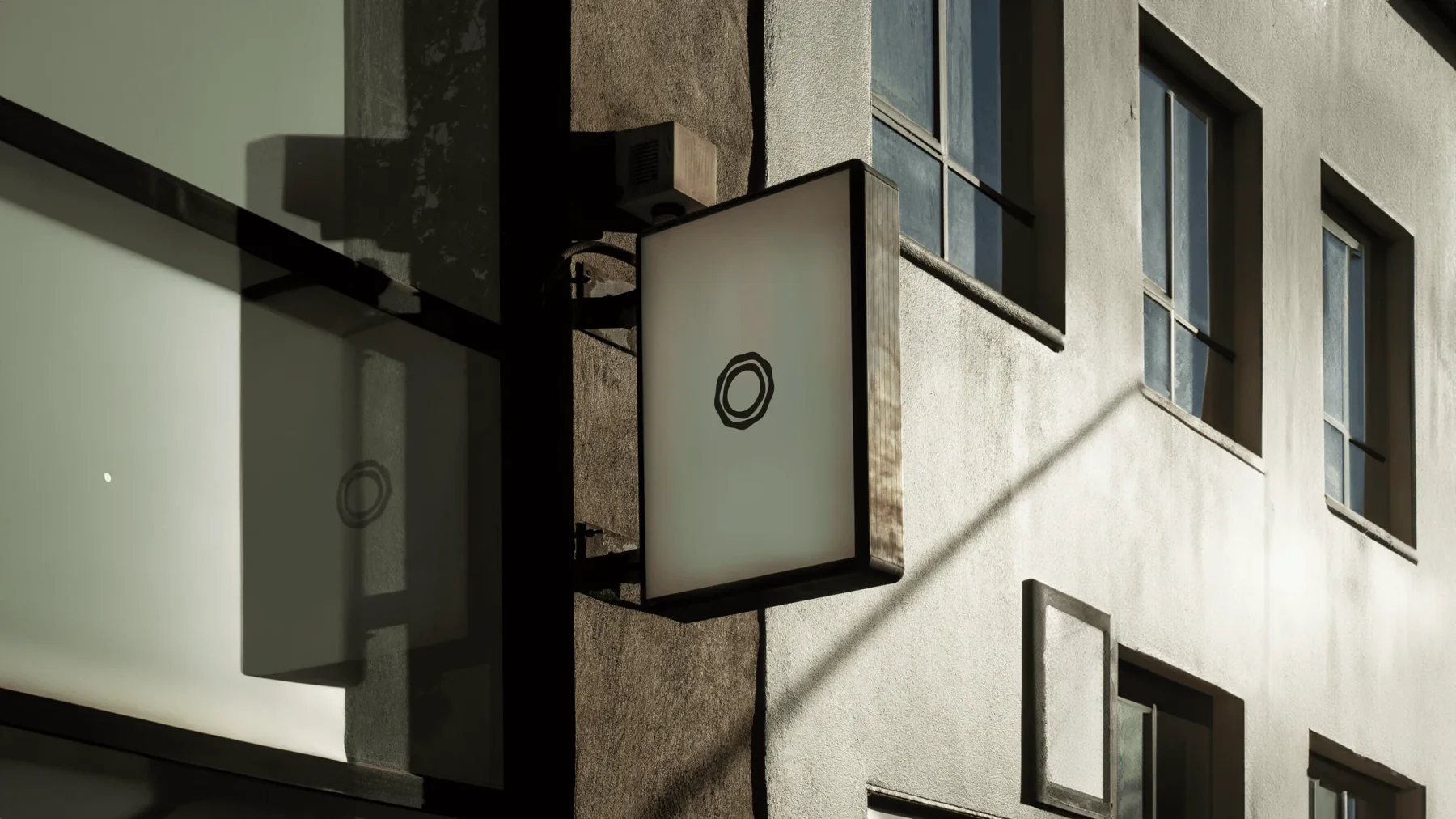 Minimal Heartwood circular sign beside a glass entrance.