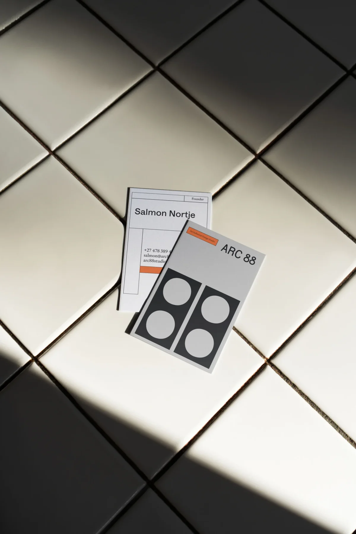 Two Arc 88 printed cards on a tiled surface.