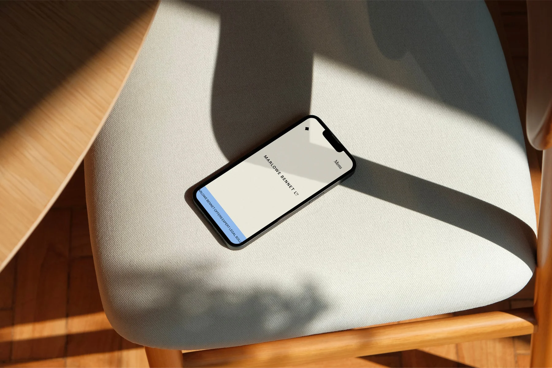 Marlowe Bennet mobile website on a phone resting on a chair.