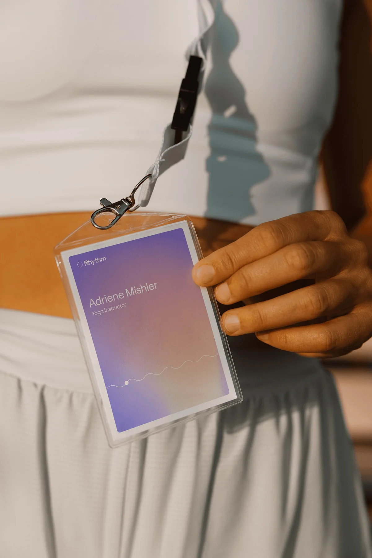 Person holding a Rhythm badge with a purple gradient.
