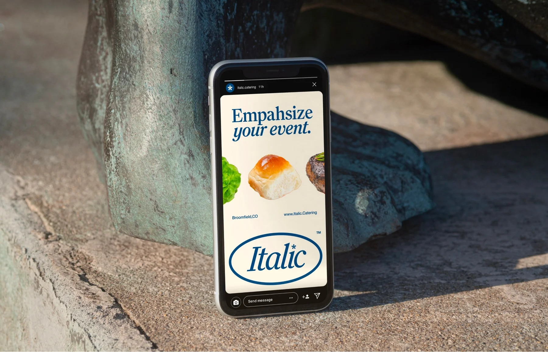 Italic mobile website displayed on a phone against a tree.