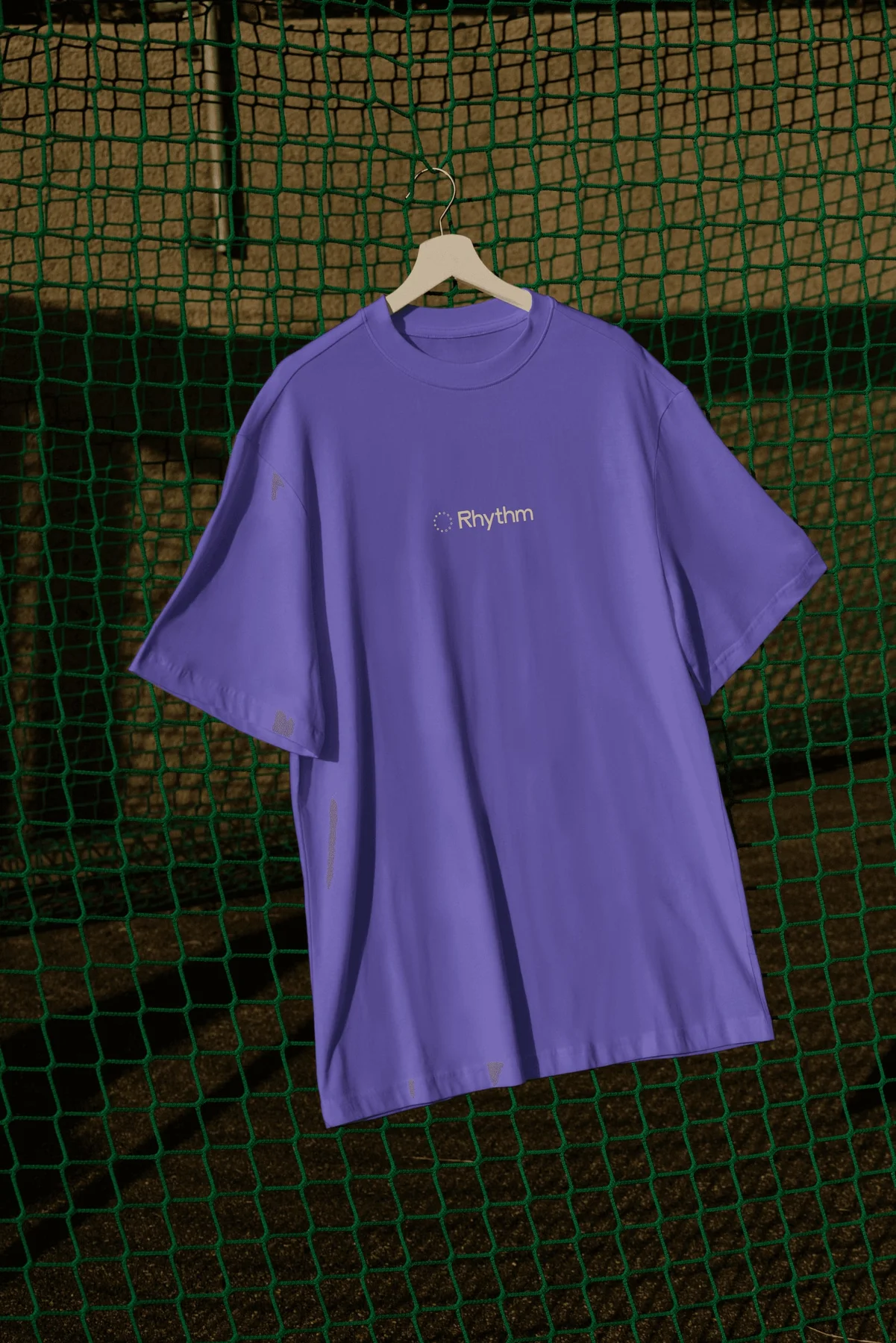Purple Rhythm T-shirt hanging on a fence.