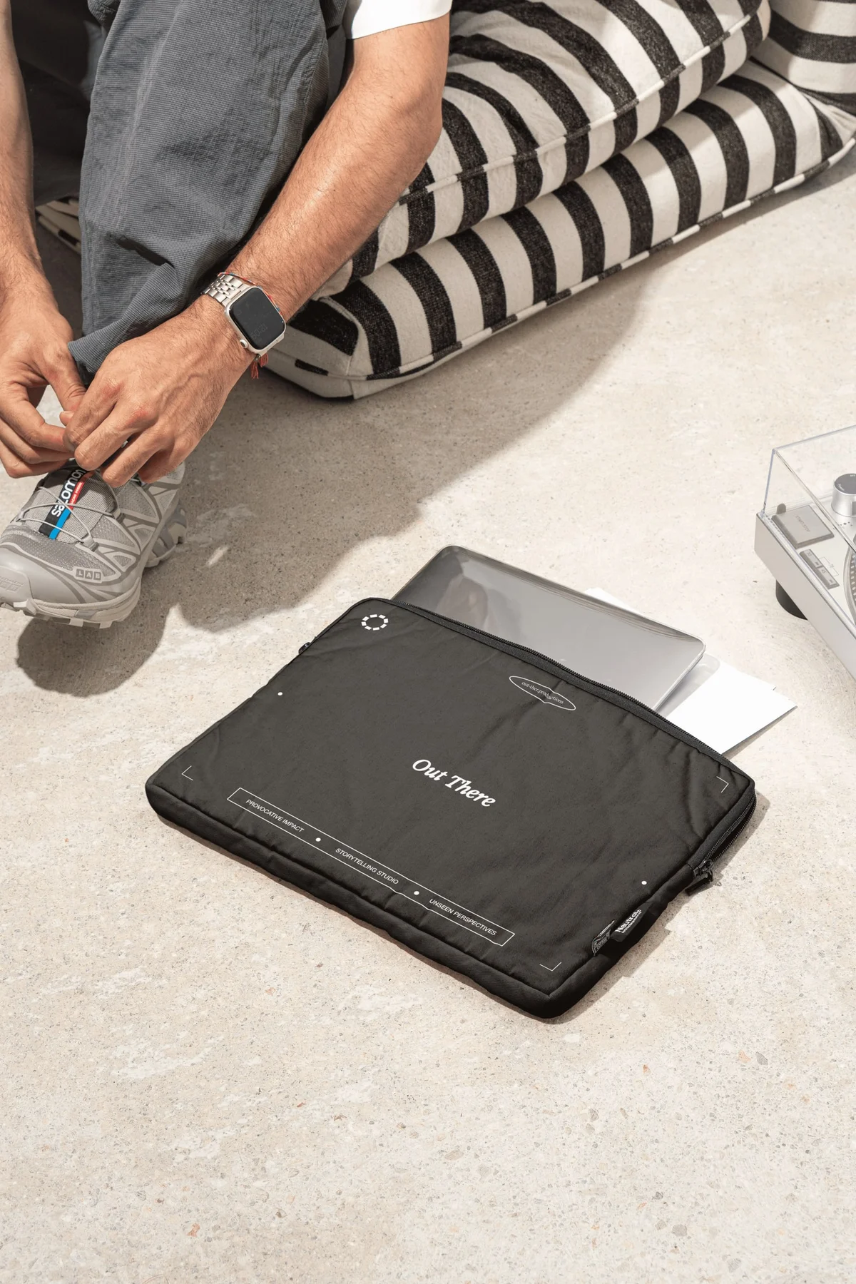 Black Out There bag beside a person tying a shoe.