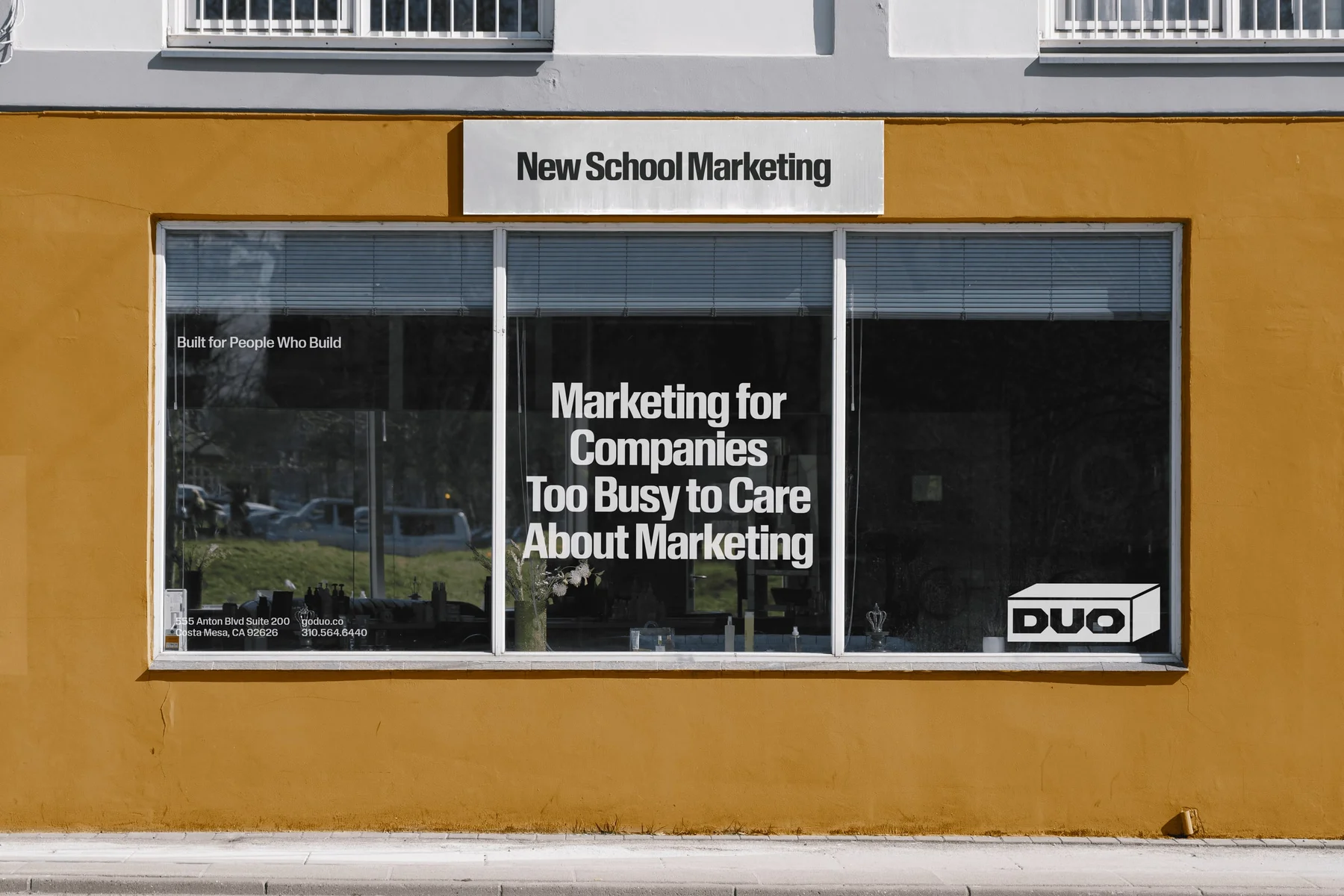 Duo window graphics on a yellow storefront.