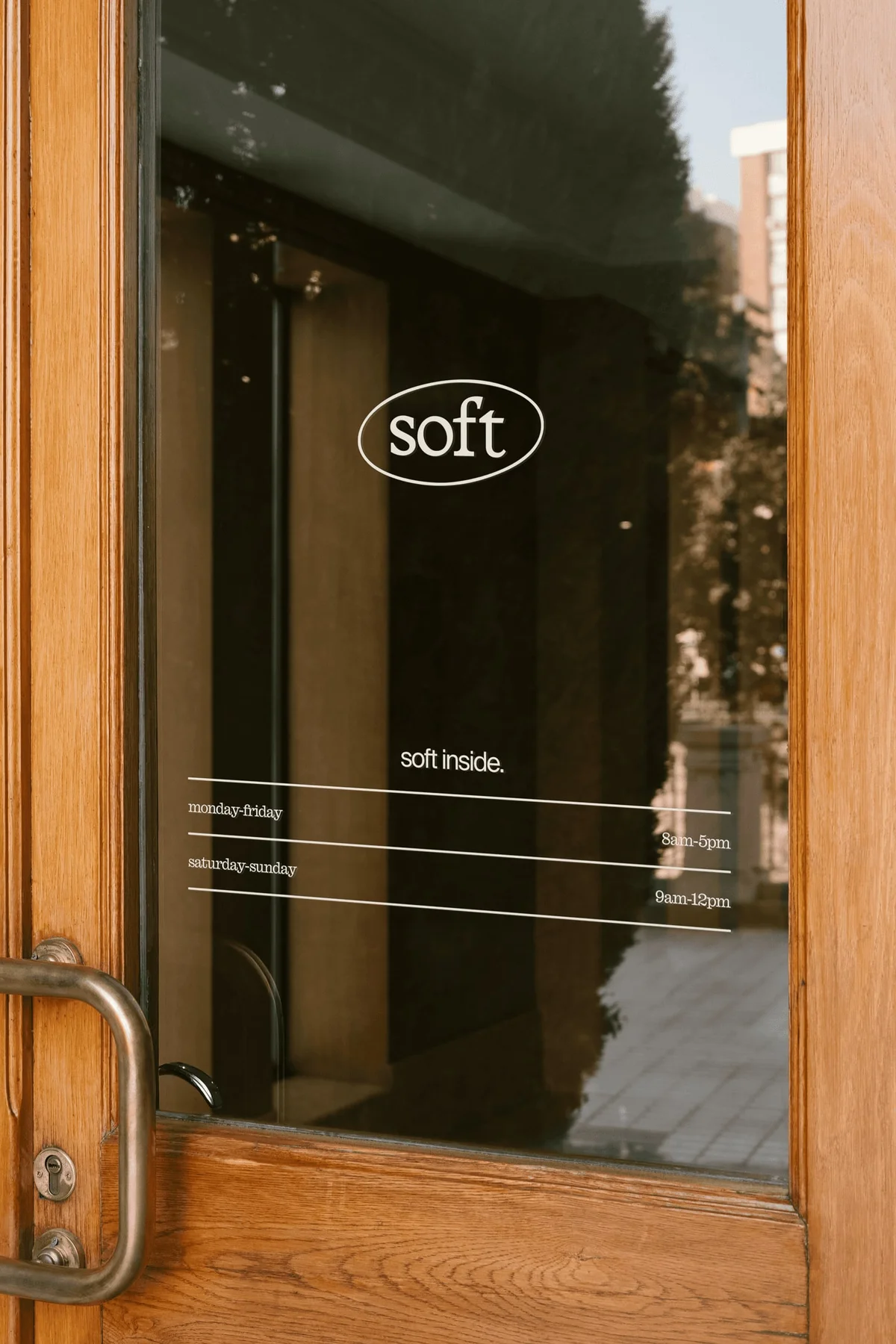 White Soft wordmark applied to a wooden cafe door.