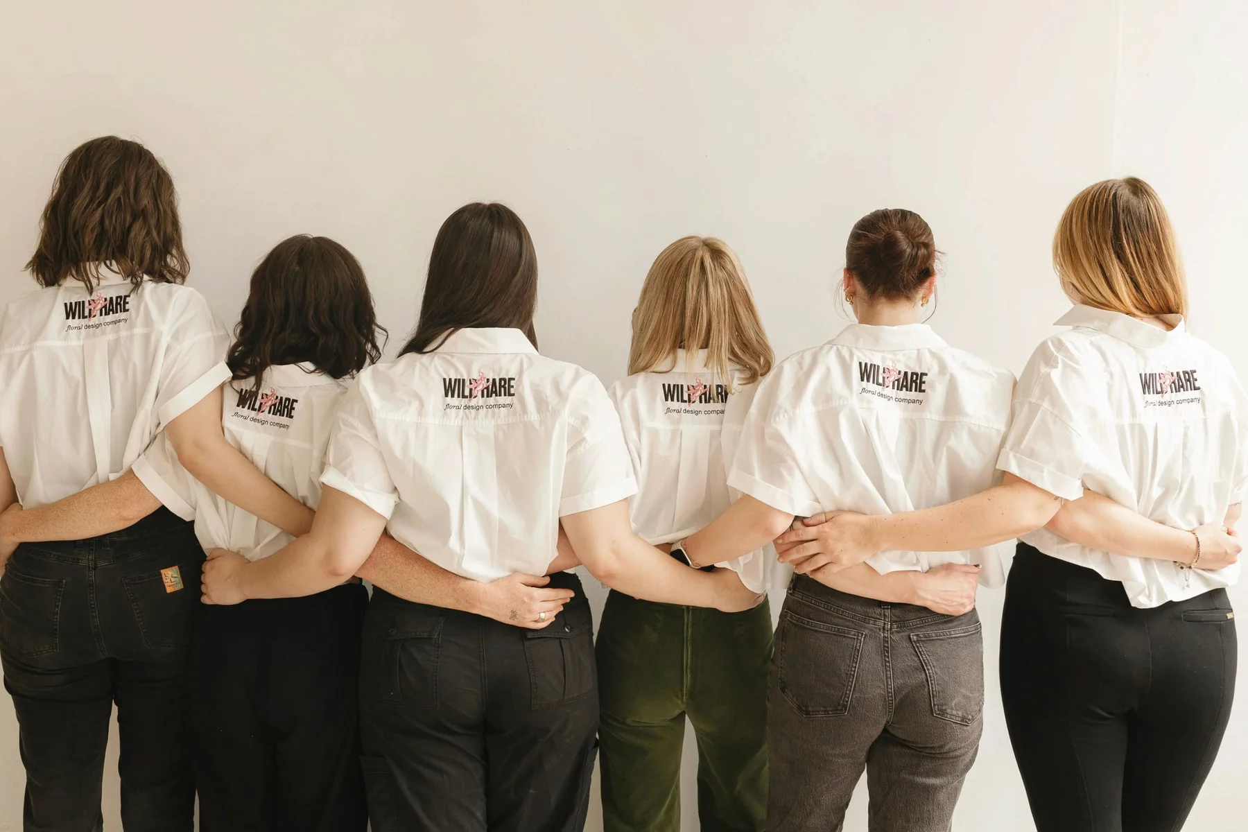 Group standing together in white Wild Hare shirts.