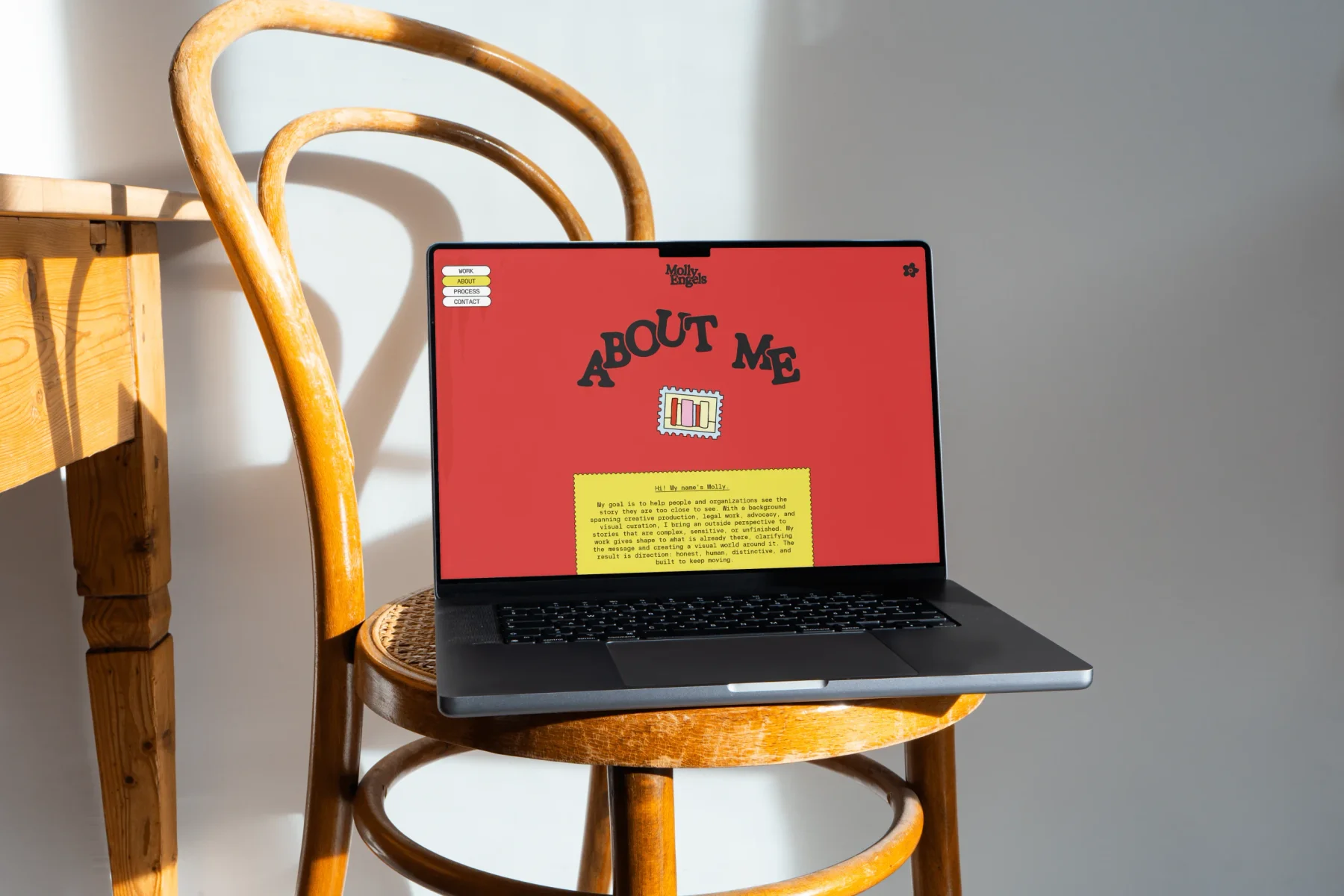 Red Molly Engels website displayed on a laptop sitting on a chair.
