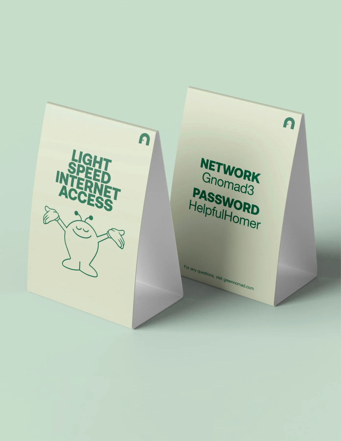 Two pale green printed signs with Green Nomad illustrations and access information.