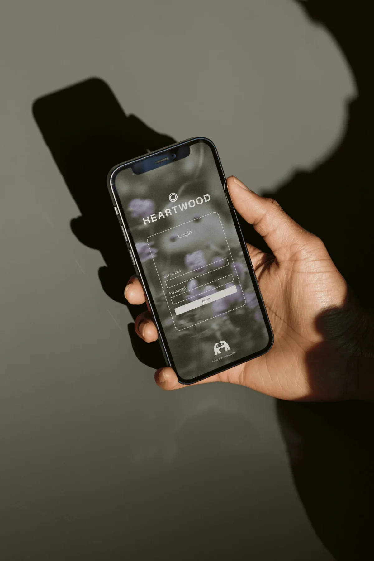 Heartwood mobile website shown on a phone held in sunlight.