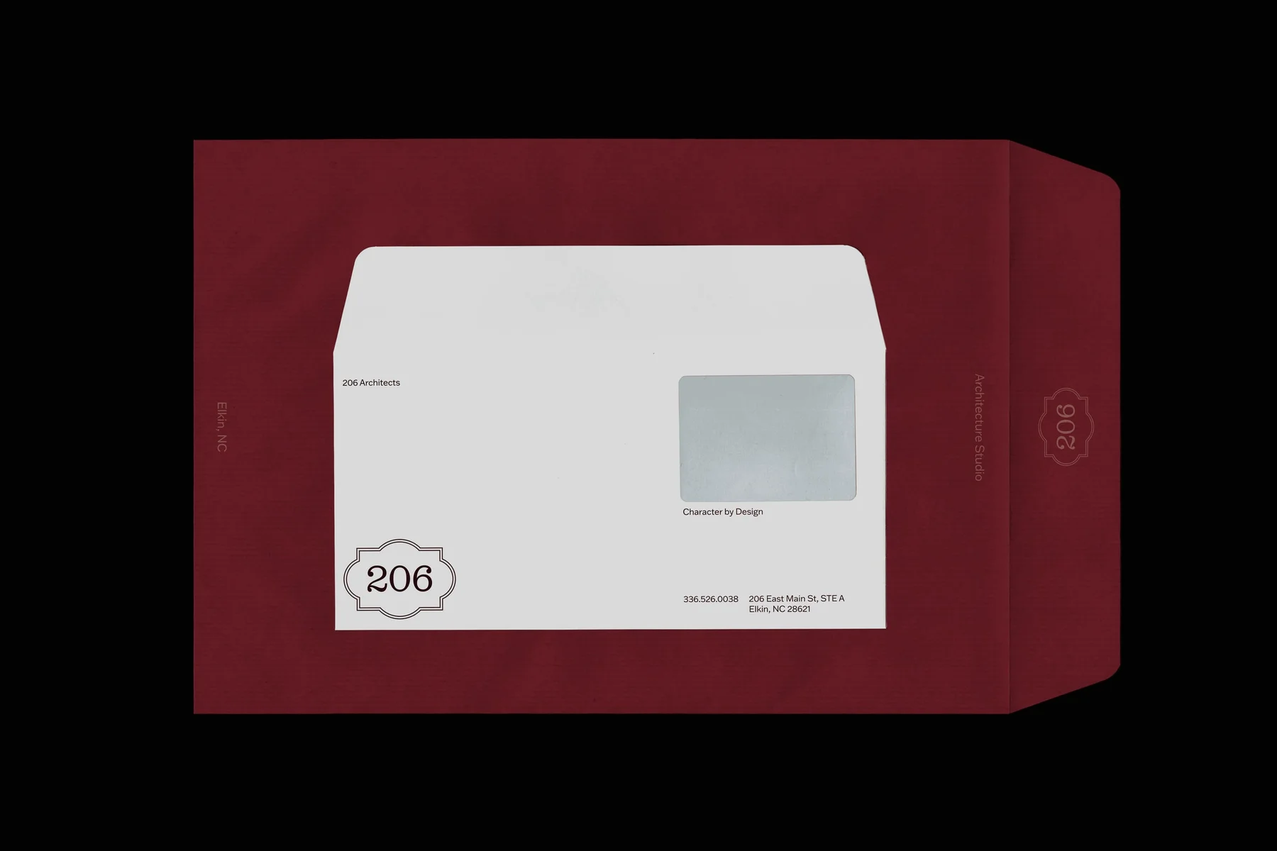 White window envelope on burgundy stationery.