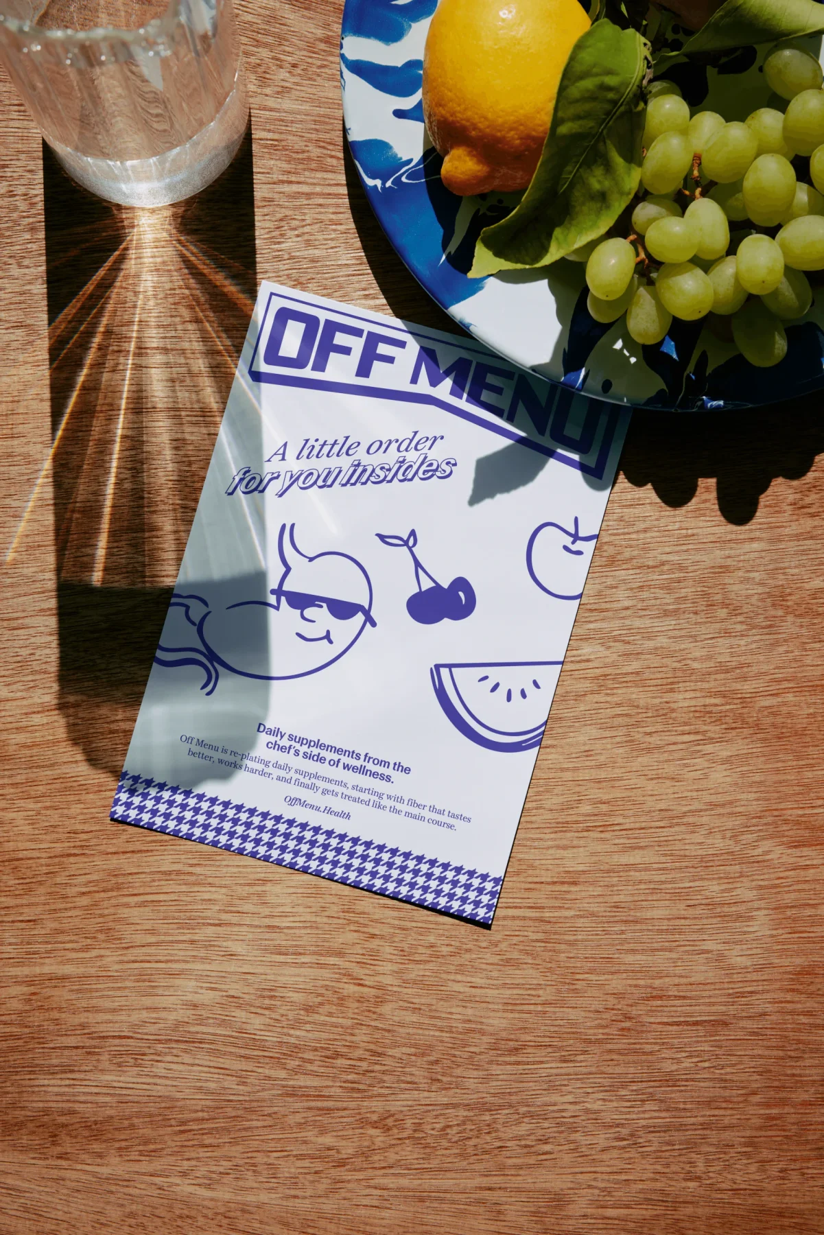 Purple Off Menu illustrated flyer on a table beside fruit.