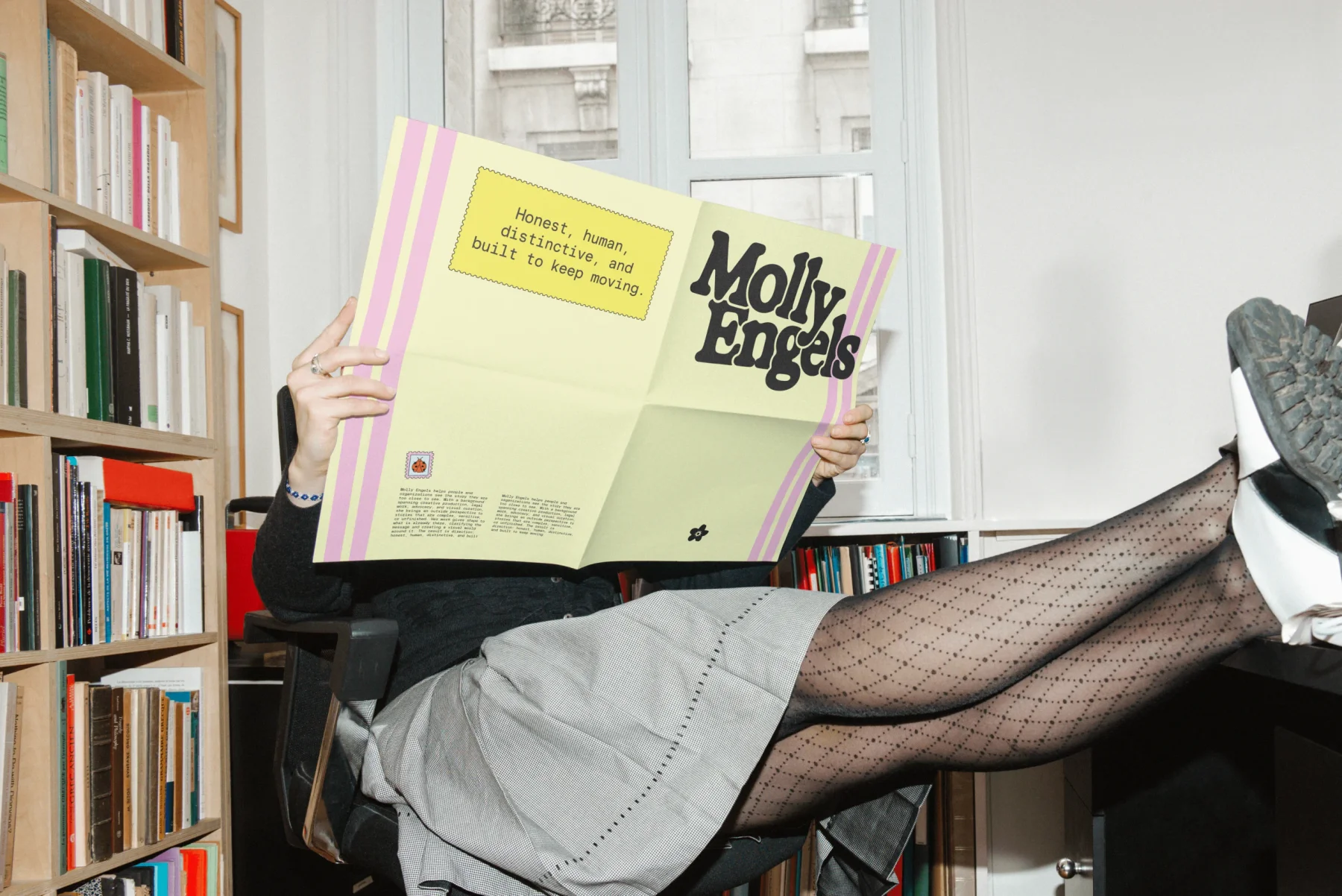Person reading an oversized pastel Molly Engels publication.
