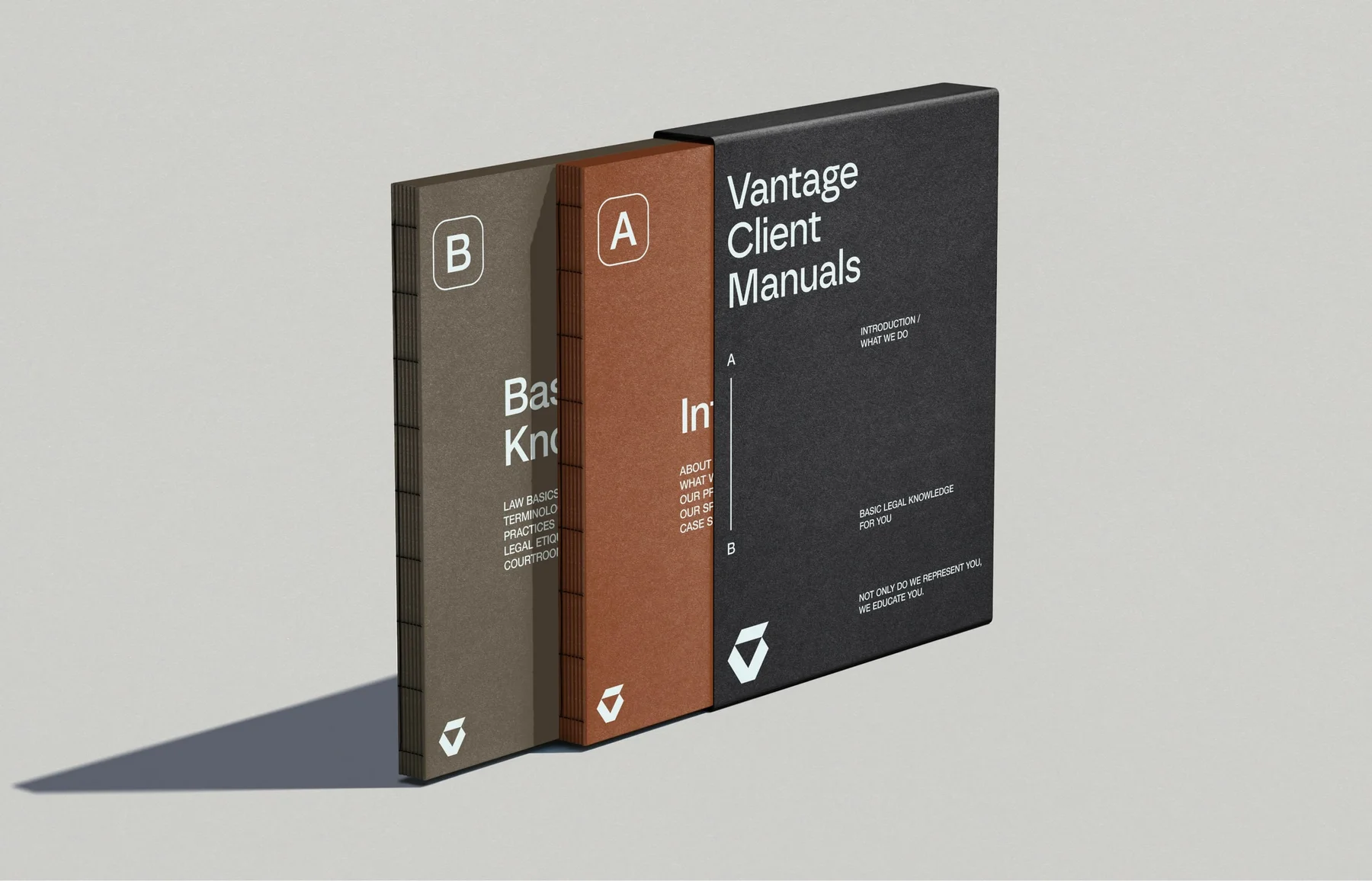 Three Vantage manuals in muted gray, brown, and charcoal.