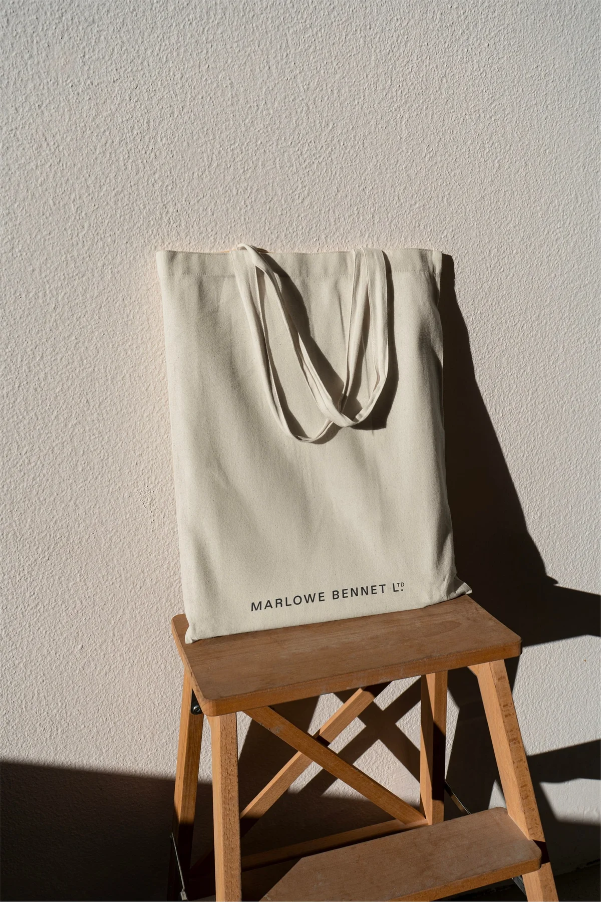 Cream Marlowe Bennet tote bag on a wooden chair.