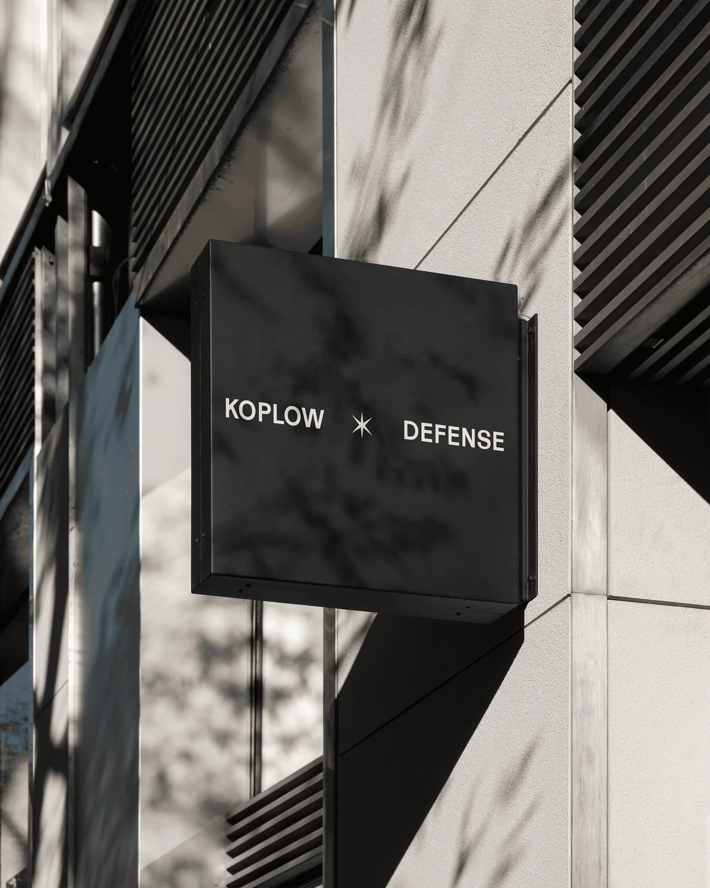 Black projecting Koplow Defense sign.