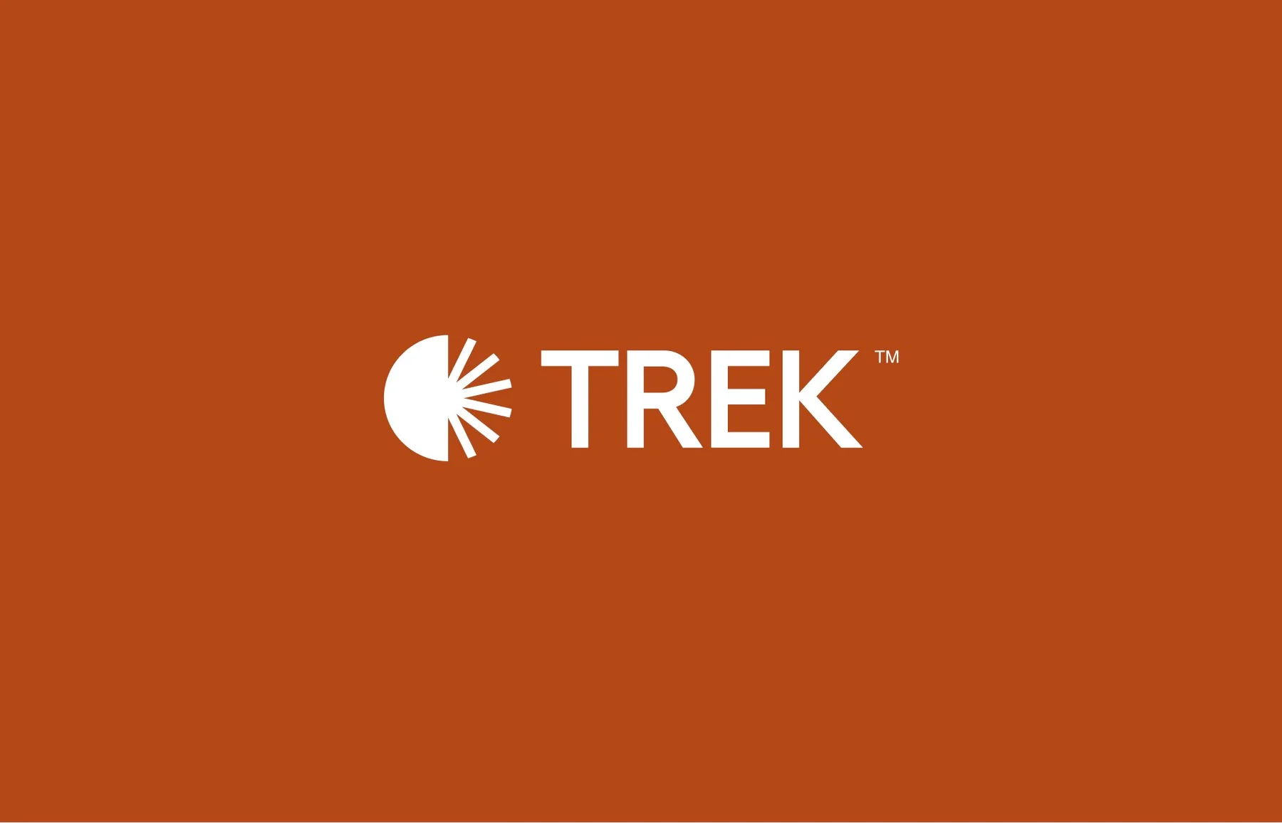 White Trek wordmark and radiating symbol on burnt orange.
