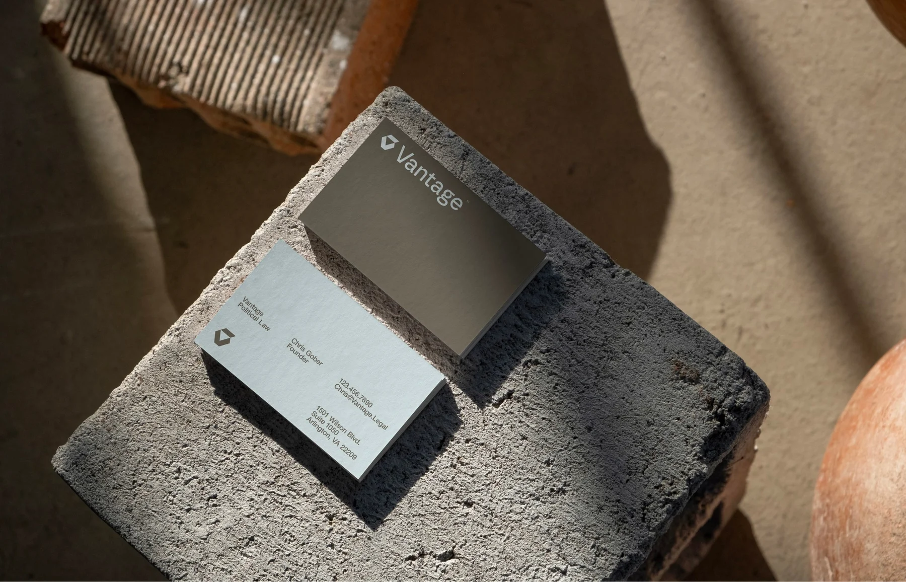 Vantage business cards on a rough stone block.
