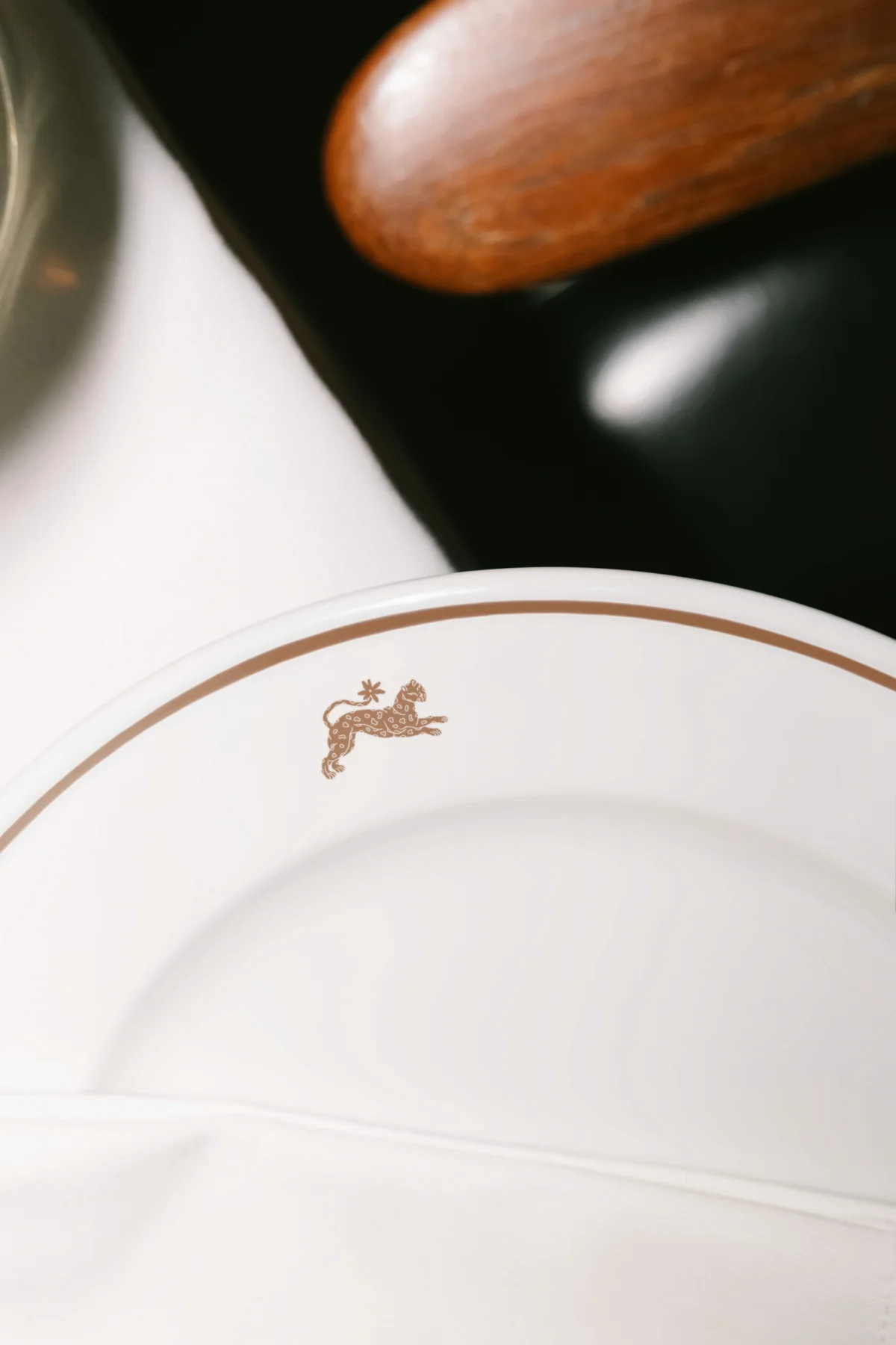 White plate with a small brown Wildflower animal emblem.