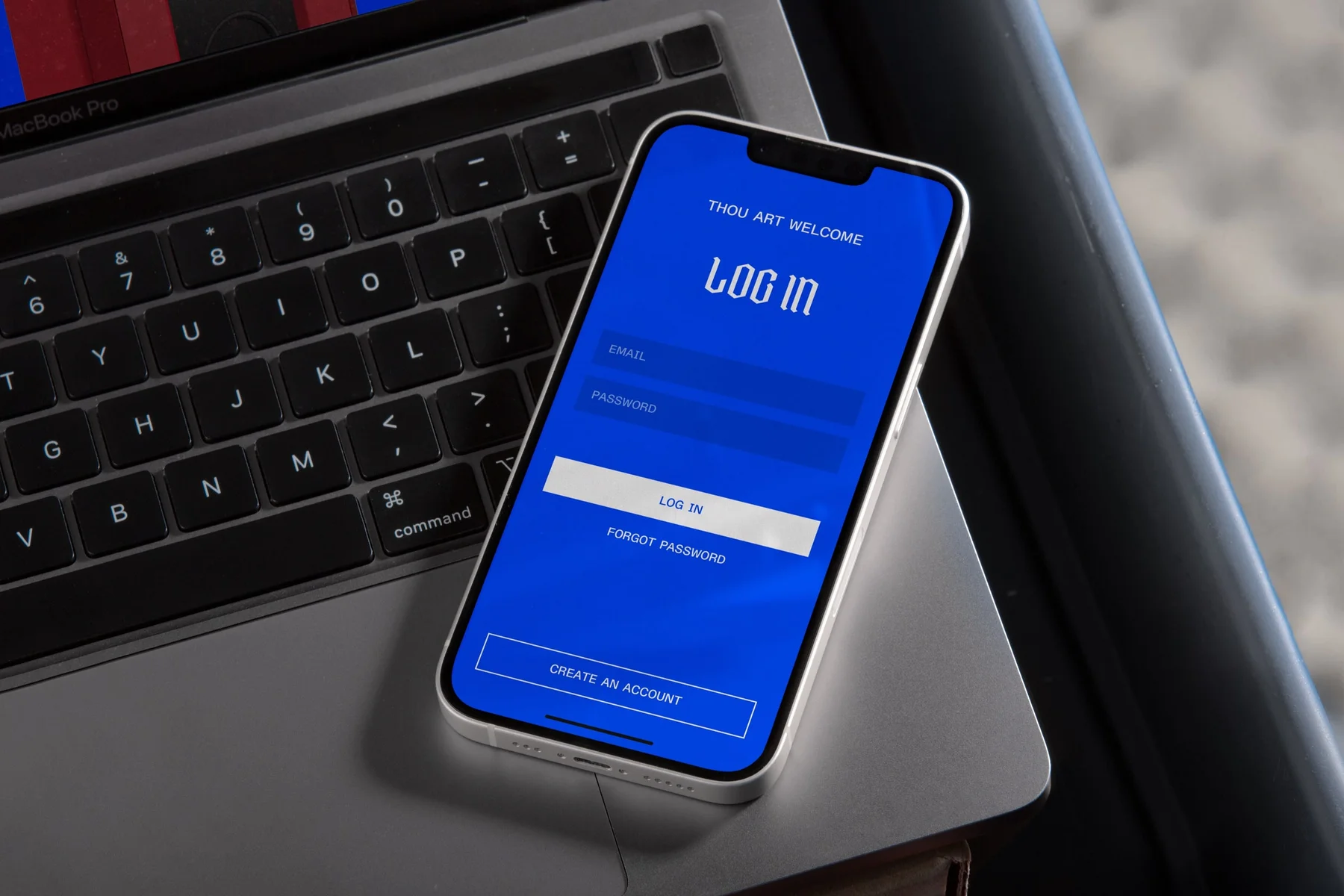Blue Moat login page displayed on a phone over a laptop.