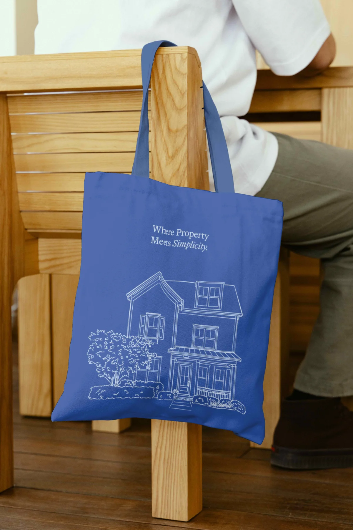 Blue Whole tote bag with a white house illustration.