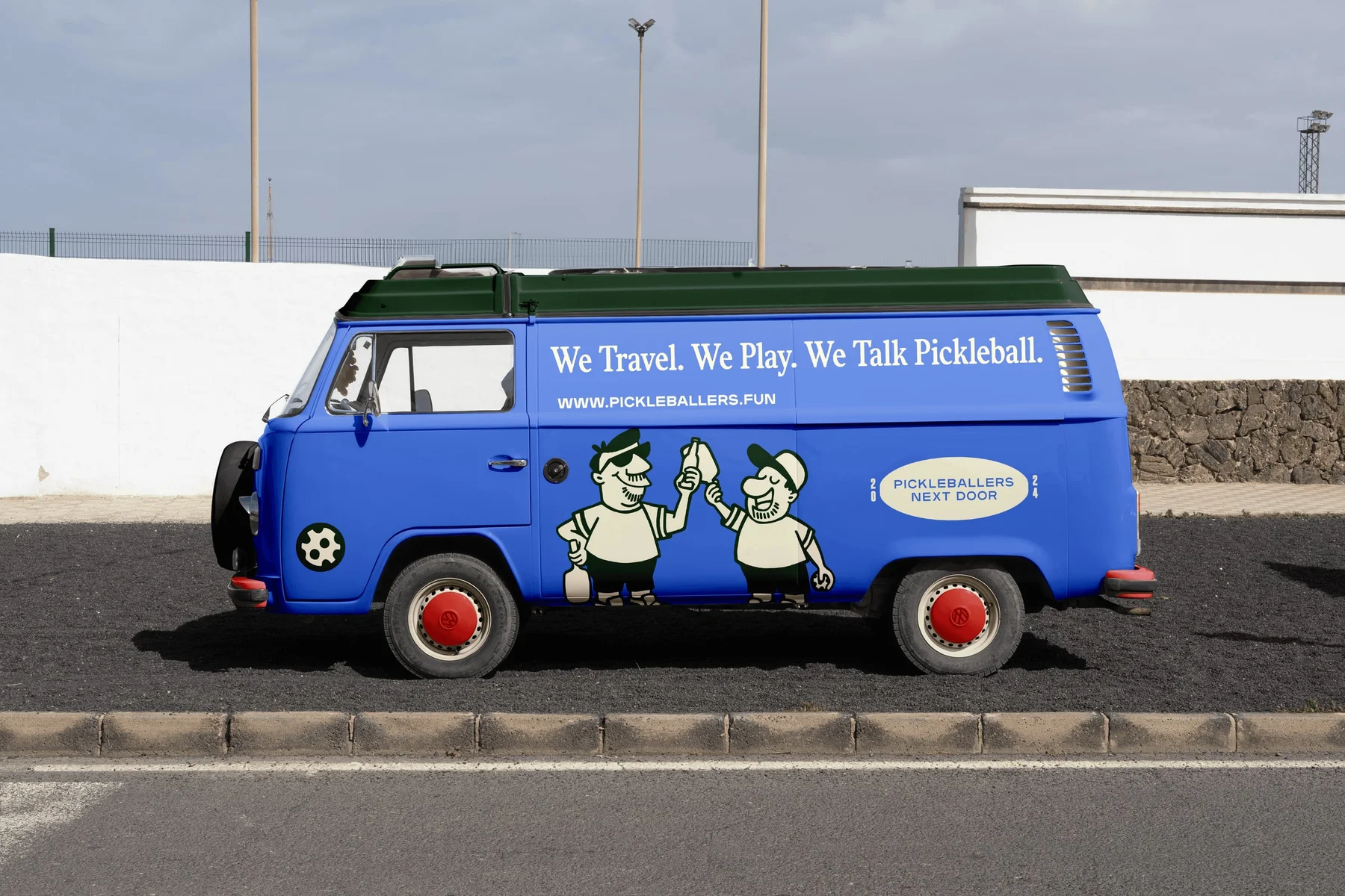 Blue Pickleballers Next Door van with illustrated characters.