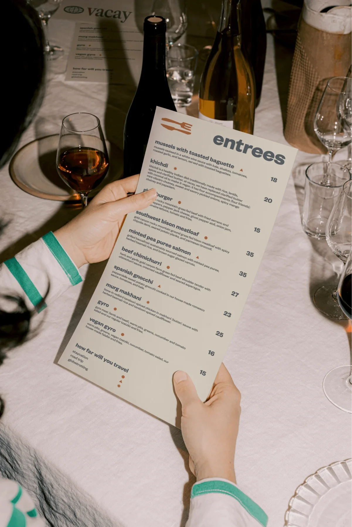 Person reading The Passenger restaurant menu at a table.