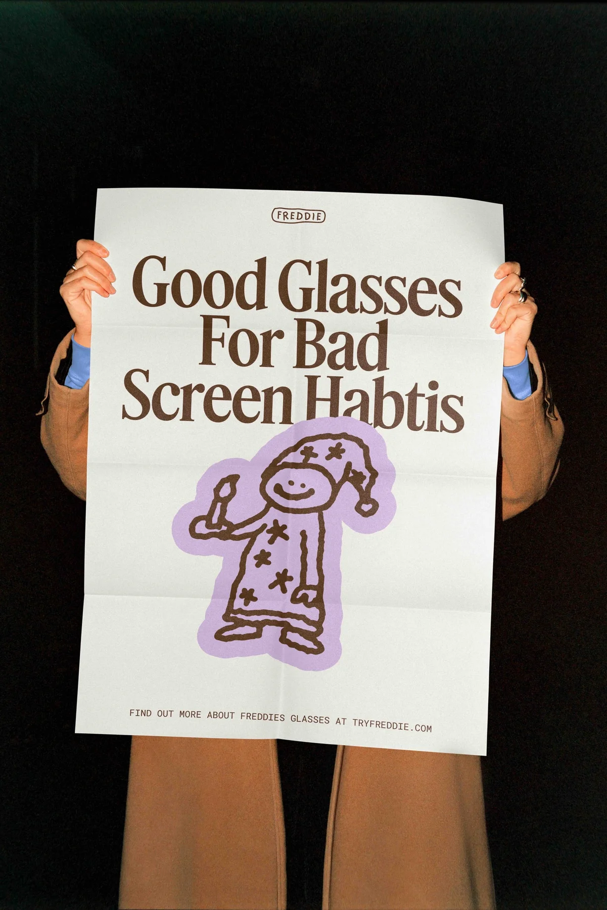 Person holding a Freddie poster reading Good Glasses for Bad Screen Habits.